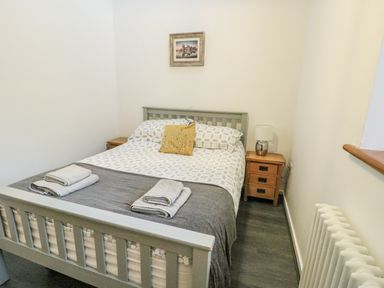 A bedroom with a bed and bedside tables at 2 Mountain View in Talwrn near Llangefni