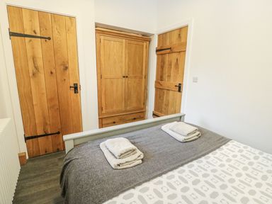 A bedroom with a bed and wardrobe at 2 Mountain View near Talwrn Llangefni