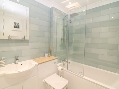 A bathroom with a sink cabinet toilet bathtub and shower at Breakers in Newquay