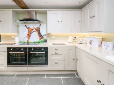 A kitchen with two built in ovens kettle toaster bread bin and canisters at Cwmfadog in Llanafan-fawr near Beulah