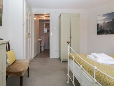 A bedroom with a bed and a small wardrobe next to a bathroom at Sethera in Ambleside