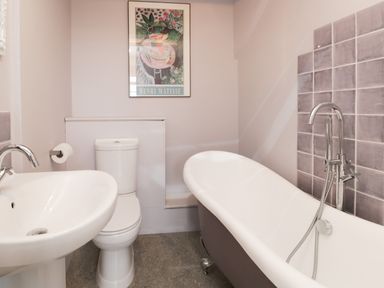 A bathroom with a sink toilet bathtub and artwork on the wall at Sethera in Ambleside