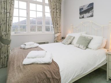 A bedroom with a bed towels on a blanket by the window at Sethera in Ambleside
