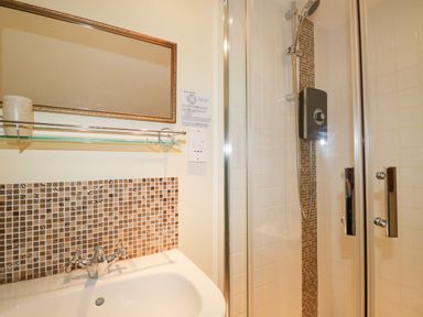 A bathroom with a sink and a shower with glass doors at Sethera in Ambleside