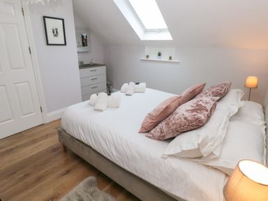 A bedroom with a bed with pillows and towels under a skylight window at Cambrie in Tenby