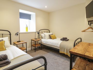 A bedroom with two single beds and bedside tables at Hen Dy Bryn Mawndy in Melin y Wig near Corwen