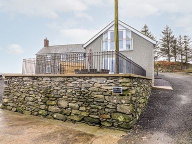 A house with a stone wall and metal railing in front at Hen Dy Bryn Mawndy Melin y Wig near Corwen