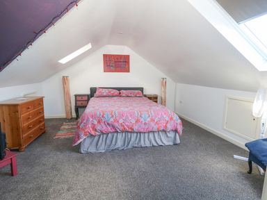 A bedroom with a bed a chest of drawers and skylights at Victorian Town House in Weymouth