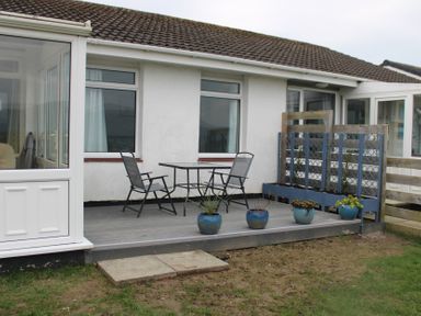 A patio with a table and chairs at Hafod-y-Gors in Fairbourne