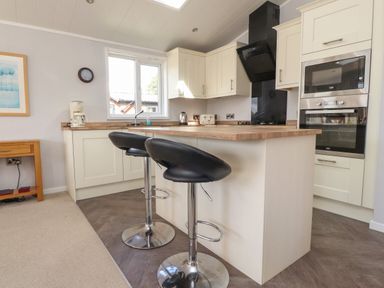 A kitchen with two black bar stools at Mereside South lakeland Leisure Village near Carnforth