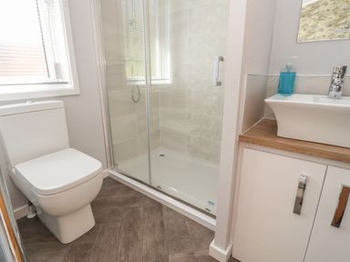 A bathroom with a toilet shower enclosure and sink at Mereside South lakeland Leisure Village near Carnforth