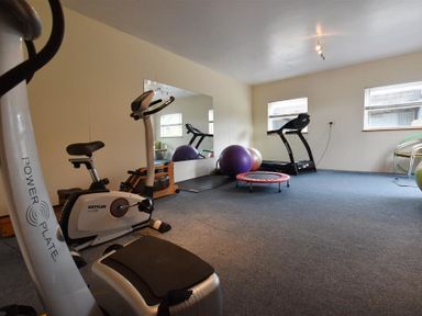 A home gym room with exercise bike treadmill exercise balls and a small trampoline at The Farmhouse in Newport Pembrokeshire