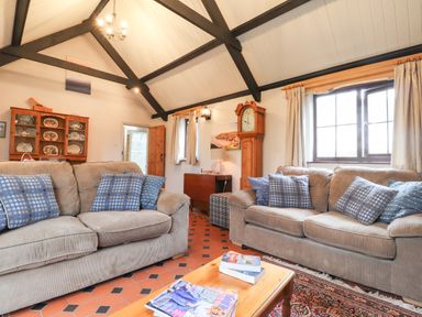 A living room with two sofas and blue patterned cushions at Bwthyn Alarch in Trefin St Davids Pembrokeshire