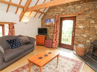 A living room with a sofa coffee table television and fireplace at The Granary in Newport Pembrokeshire