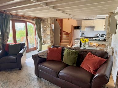 A living room with a sofa and armchairs at Stable Cottage in Newport, Pembrokeshire
