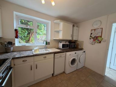 A kitchen with a sink, washing machine, and dishwasher at Derlwyn, Newport, Pembrokeshire