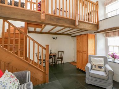 A living room featuring a dining table and chairs at West End Cottage Newport, Pembrokeshire