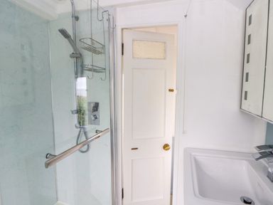 A bathroom with a shower and sink at Clifftop Carriage in Aberporth, Ceredigion