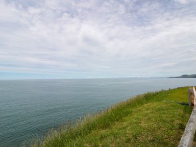 A view of the sea and grass at Clifftop Carriage in Aberporth, Ceredigion