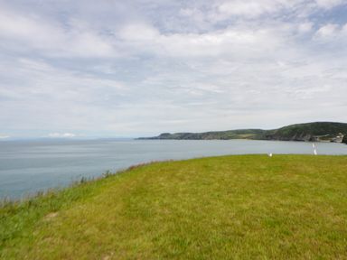 A view of the sea from a grassy area at Clifftop Carriage in Aberporth, Ceredigion