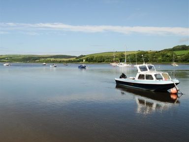 A body of water with several boats anchored and green hills in the background at Gellifor in St Dogmaels Pembrokeshire