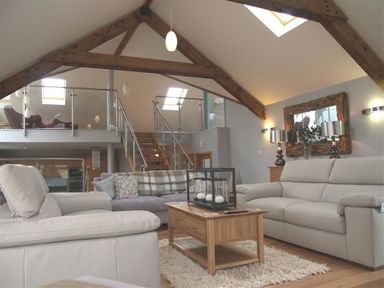 A living room with sofas coffee table and wooden beams in Seabrook Broad Haven Pembrokeshire