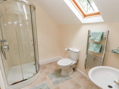 A bathroom with a shower cubicle toilet sink and towel rack at Gwyddno Lodge in Narberth Pembrokeshire