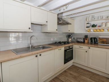 A kitchen with sink, stove, and oven at End Cottage in Newport, Pembrokeshire