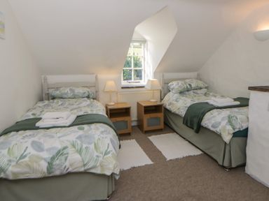 A bedroom with two beds and nightstands at End Cottage Newport, Pembrokeshire