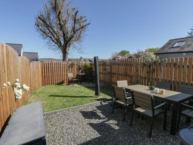 A garden with seating and a tree at End Cottage Newport, Pembrokeshire