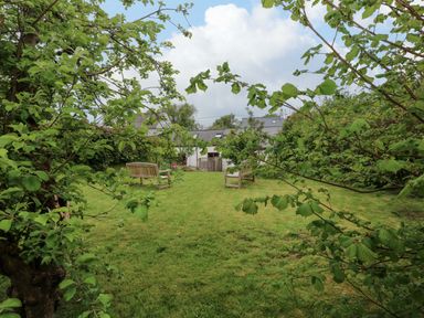 A garden with grass and seating at Brynawelon Newport, Pembrokeshire