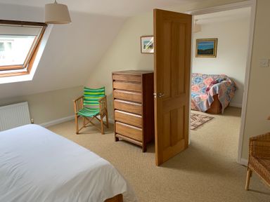 A bedroom with a bed and dresser at Brynawelon, Newport, Pembrokeshire