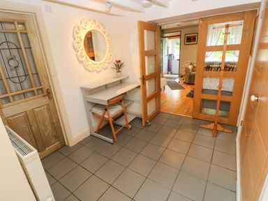 An entrance hall with a mirror and shelves at Greenbanks in Dinas Cross, Pembrokeshire