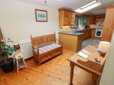 A kitchen with wooden furniture and cabinets at Greenbanks in Dinas Cross, Pembrokeshire