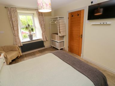 A bedroom with a bed and a window at Greenbanks in Dinas Cross, Pembrokeshire