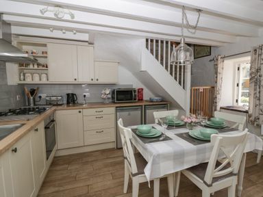 A kitchen with dining table and appliances at Middle Cottage in Newport, Pembrokeshire