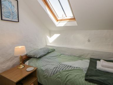 A bedroom with a bed and a lamp at Middle Cottage in Newport, Pembrokeshire