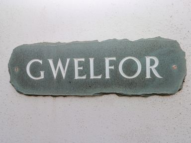 A stone plaque with the word gwelfor on a white wall at Gwelfor Marloes