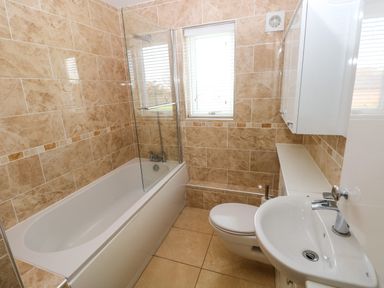 A bathroom with a bathtub a toilet a sink and a window at Gwelfor Marloes Marloes Pembrokeshire