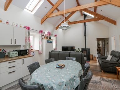 A kitchen with a dining table and seating at Y Felin Cardigan Ceredigion