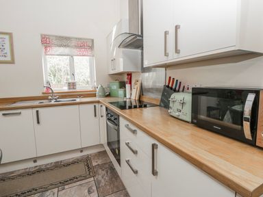 A kitchen with a sink and stove at Y Felin in Cardigan, Ceredigion