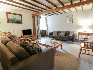 A living room with sofas and a television at Dewi Villa Aberarth, Ceredigion
