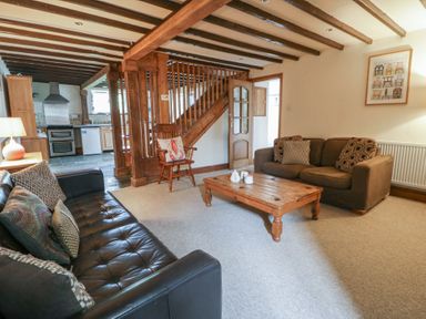 A living room with sofas and a coffee table at Dewi Villa in Aberarth, Ceredigion