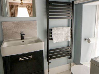 A bathroom with sink, towel rail, and toilet at Dewi Villa, Aberarth, Ceredigion