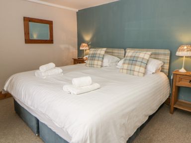 A bedroom with a double bed and lamp at Dewi Villa Aberarth, Ceredigion