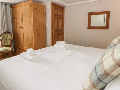 A bedroom with a bed and wardrobe at Dewi Villa Aberarth, Ceredigion