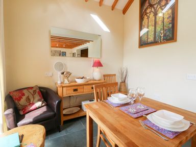 A dining room with a table set for two at Dan Castell Cottage, Llandeilo, Carmarthenshire