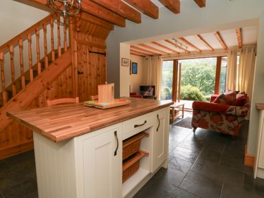 A kitchen with a wooden island and open space at Dan Castell Cottage in Llandeilo, Carmarthenshire