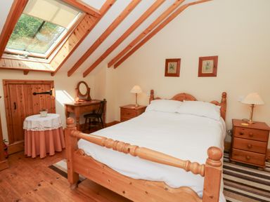 A bedroom with a bed and furniture at Dan Castell Cottage in Llandeilo, Carmarthenshire