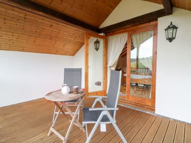 A balcony with a table and chairs at Dan Castell Cottage in Llandeilo, Carmarthenshire